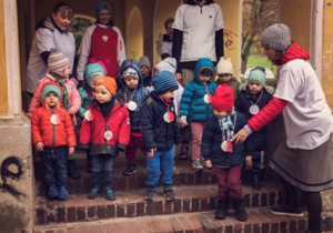 Nauczycielka ustawia dzieci na schodach