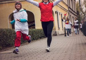 Kobieta z dziewczynką biegną do mety