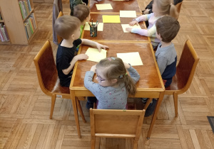dzieci wykonują zakładki do książki przy stoliku
