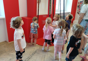 Dzieci oglądają eksponaty w muzeum.
