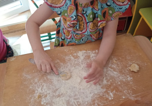 Dziewczynka robi maślane ciasteczka w przedszkolu.