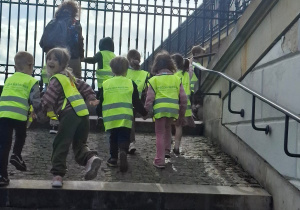 Dzieci na wycieczce wchodzą po schodach.