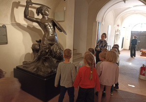 Dzieci podczas wizyty w Muzeum Warszawy oglądają eksponaty.