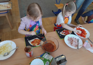 dzieci przygotowuja swoją pizzę