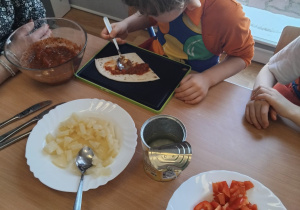 dzieci przygotowują swoją pizzę