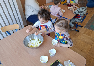 dzieci dodają serek do owoców