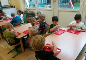 dzieci siedzące przy stolikach