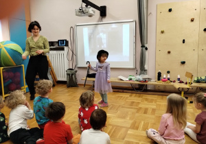 Dzieci na sali gimnastycznej biorą udział w zajęciach na temat kina niemego.