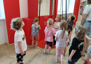 Dzieci oglądają eksponaty w muzeum.