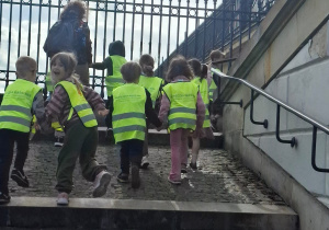 Dzieci na wycieczce wchodzą po schodach.