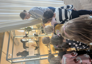 Dzieci oglądają eksponaty w muzeum.