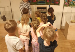 Dzieci oglądają eksponaty w muzeum.