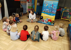 Dzieci siedzą w kole podczas zajęć.