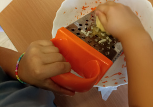 Dzieci przygotowują warzywa do gofrów.