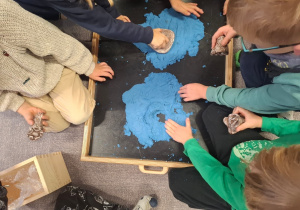 Dzieci bawią się piaskiem kinetycznym.