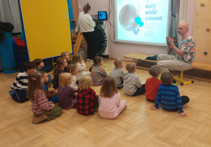 Dzieci oglądają prezentację na warsztatach.