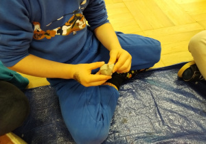 Dziecko lepi rzeźbę ptaka.