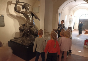 Dzieci podczas wizyty w Muzeum Warszawy oglądają eksponaty.