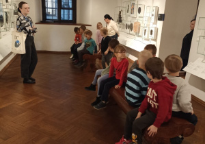 Dzieci podczas wizyty w Muzeum Warszawy oglądają eksponaty.