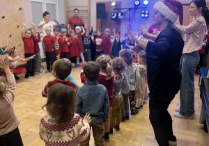 Dzieci bawią się na sali gimnastycznej z okazji Mikołajek.