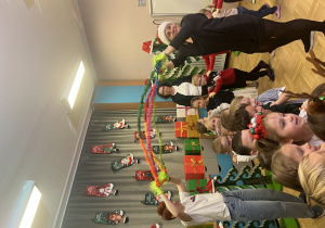 Dzieci bawią się na sali gimnastycznej z okazji Mikołajek.