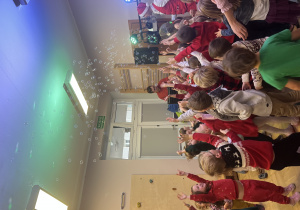 Dzieci bawią się na sali gimnastycznej z okazji Mikołajek.