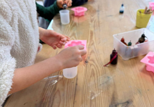 dzieci wlewają barwniki i zapachy do kubeczków