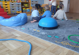 dzieci siedzą na dywanie