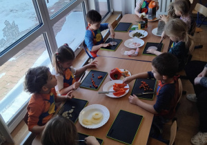 dzieci przygotowują dodatki do pizzy