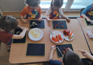 dzieci kroją warzywa