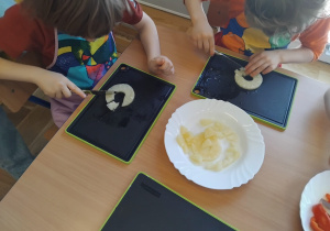 dzieci kroją ananasa