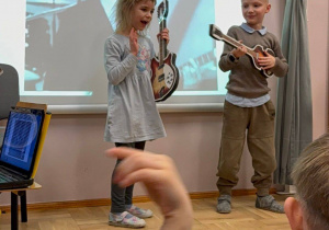 dziewczynka i chłopiec grają na gitarach